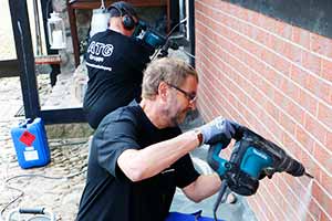 Die Spezialisten der ATG bei der Durchführung einer Mauerwerkstrockenlegung Mitarbeiter von ATG bei der Mauerwerkstrockenlegung