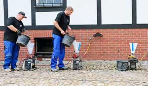 Erneuerung der Horizontalsperre mit Mauerwerksinjektion Handwerker der ATG erneuern die Horizontalsperre mit dem Injektionsverfahren